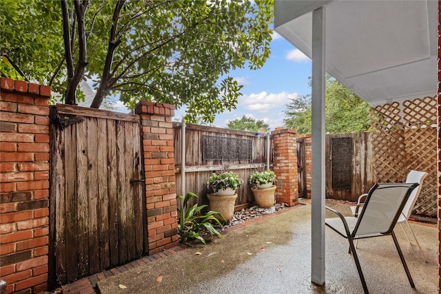 view of patio with a gate and fence