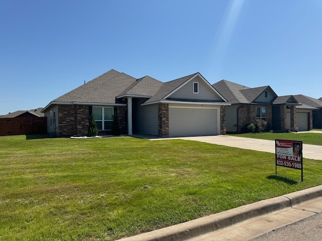view of front facade with driveway, fence, a garage, a shingled roof, and a front yard