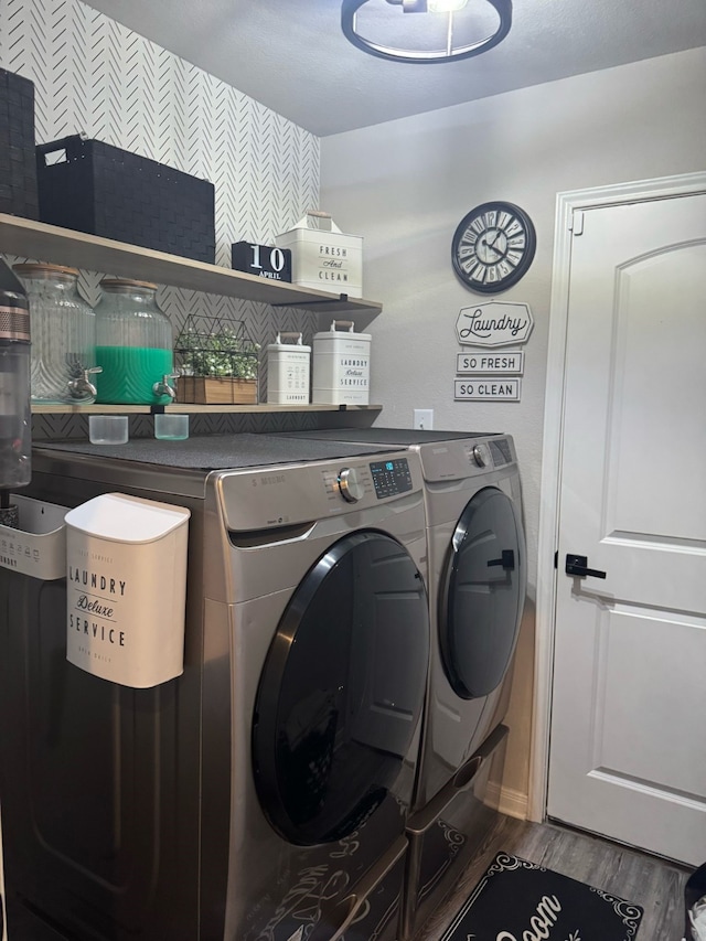 laundry area with laundry area, wallpapered walls, independent washer and dryer, and wood finished floors