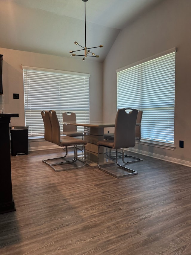 dining area featuring an inviting chandelier, lofted ceiling, baseboards, and wood finished floors