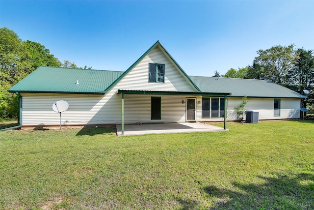 rear view of house with metal roof, a patio area, cooling unit, and a lawn