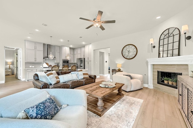 1504 Bearpath Way, Gunter, TX 75058 - living room featuring a tiled fireplace, ceiling fan, light wood finished floors, and recessed lighting