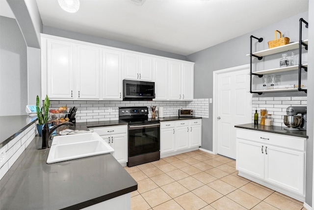 kitchen with a sink, stainless steel microwave, electric stove, backsplash, and dark countertops