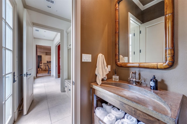 bathroom with crown molding, visible vents, tile patterned flooring, and a sink