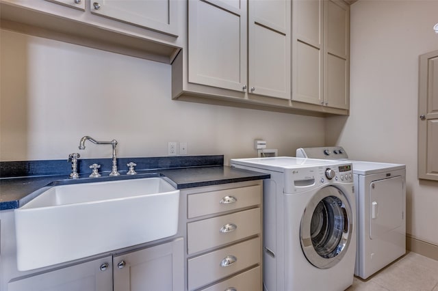 laundry area with cabinet space, washing machine and clothes dryer, light tile patterned flooring, and a sink