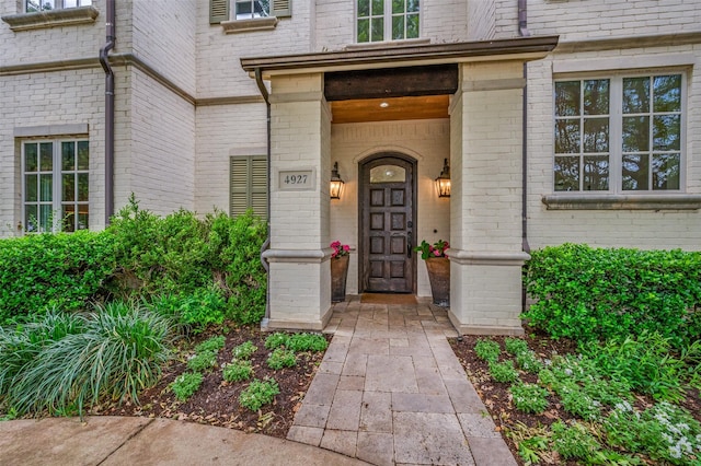 view of exterior entry featuring brick siding