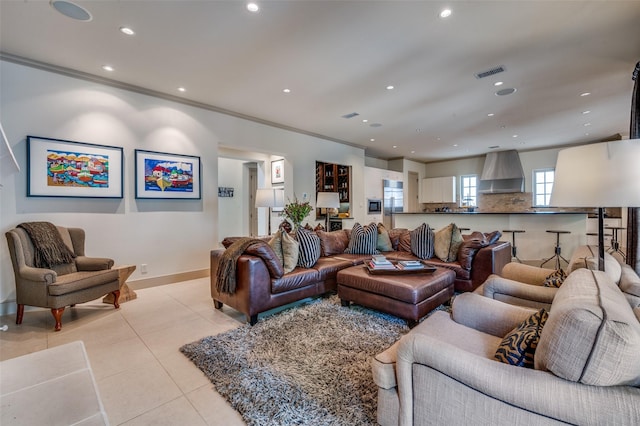 living area featuring light tile patterned floors, crown molding, visible vents, and recessed lighting