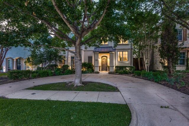 4927 Stanford Ave, Dallas, TX 75209 - obstructed view of property featuring stucco siding, a standing seam roof, curved driveway, and a metal roof