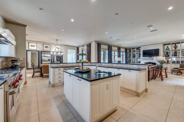 kitchen featuring a sink, range with two ovens, light tile patterned floors, and a large island