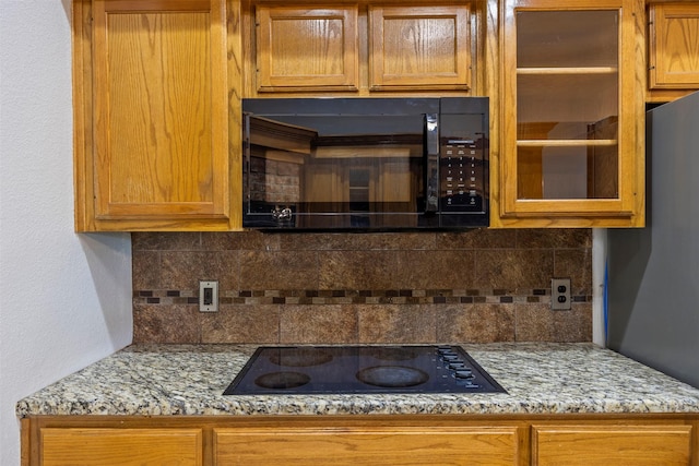 609 S Ruidoso Downs Dr, Robinson, TX 76706 - kitchen featuring glass insert cabinets, brown cabinets, black appliances, and backsplash