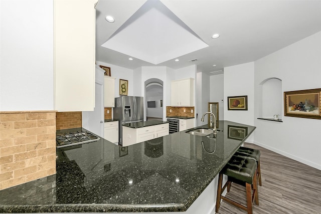 10110 Andre Dr, Irving, TX 75063 - kitchen with beverage cooler, a sink, a peninsula, decorative backsplash, and stainless steel appliances