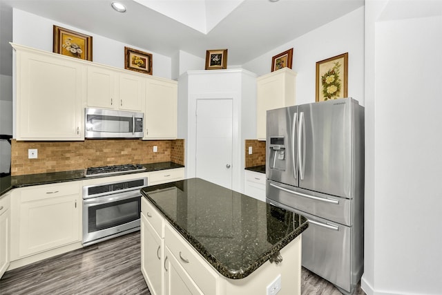10110 Andre Dr, Irving, TX 75063 - kitchen featuring a kitchen island, backsplash, dark stone counters, appliances with stainless steel finishes, and wood finished floors