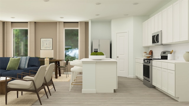 kitchen with a breakfast bar, light wood finished floors, stainless steel stove, refrigerator with ice dispenser, and a kitchen island
