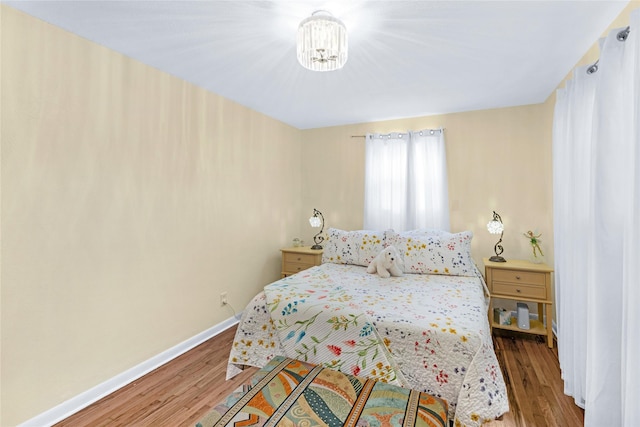 337 S Dobson St, Burleson, TX 76028 - bedroom featuring wood finished floors, baseboards, and a chandelier
