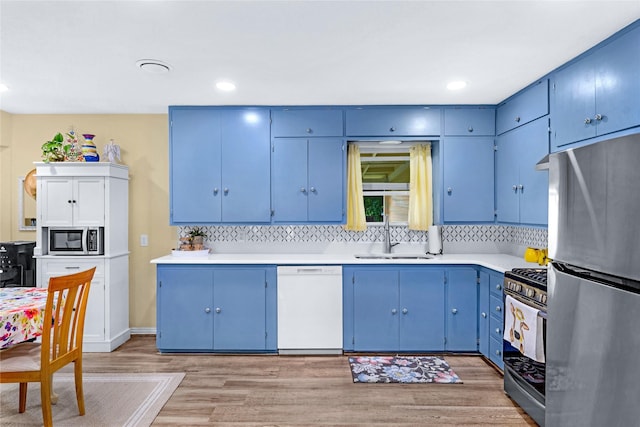 337 S Dobson St, Burleson, TX 76028 - kitchen with appliances with stainless steel finishes, a sink, blue cabinetry, light wood-style flooring, and light countertops