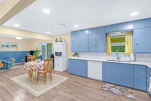 337 S Dobson St, Burleson, TX 76028 - kitchen featuring blue cabinets, white dishwasher, stainless steel microwave, a sink, and backsplash