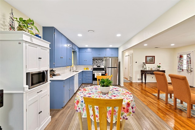 337 S Dobson St, Burleson, TX 76028 - kitchen with blue cabinets, stainless steel appliances, light countertops, light wood-type flooring, and recessed lighting