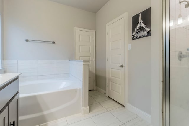 bathroom with a bath, baseboards, tile patterned flooring, a shower stall, and vanity