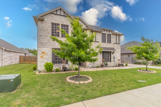 traditional-style house featuring stone siding, brick siding, a front lawn, and fence