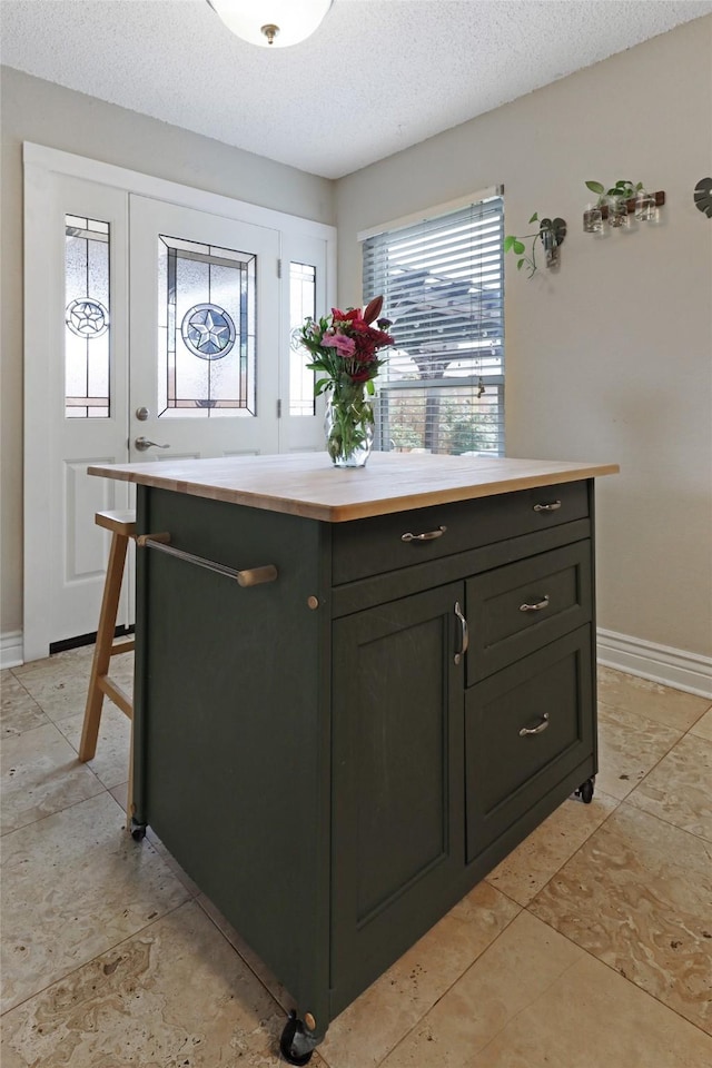 7340 Blackthorn Dr, Fort Worth, TX 76137 - kitchen with wood counters, a textured ceiling, baseboards, and a kitchen island