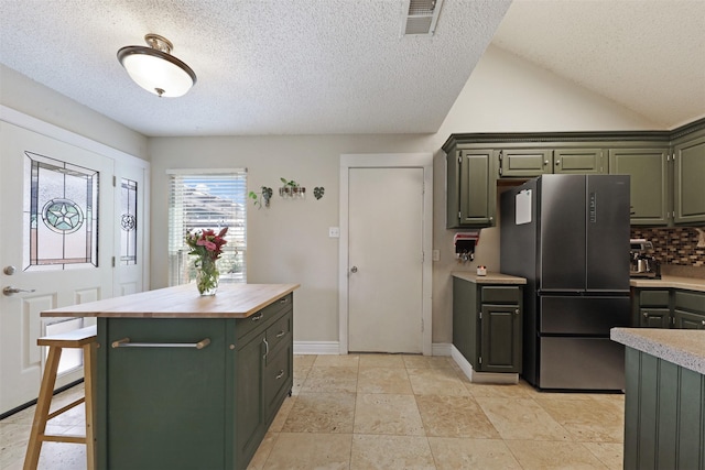 7340 Blackthorn Dr, Fort Worth, TX 76137 - kitchen with freestanding refrigerator, green cabinetry, wood counters, a textured ceiling, and backsplash