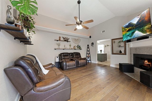 7340 Blackthorn Dr, Fort Worth, TX 76137 - living area featuring vaulted ceiling, a ceiling fan, wood finished floors, and a warm lit fireplace