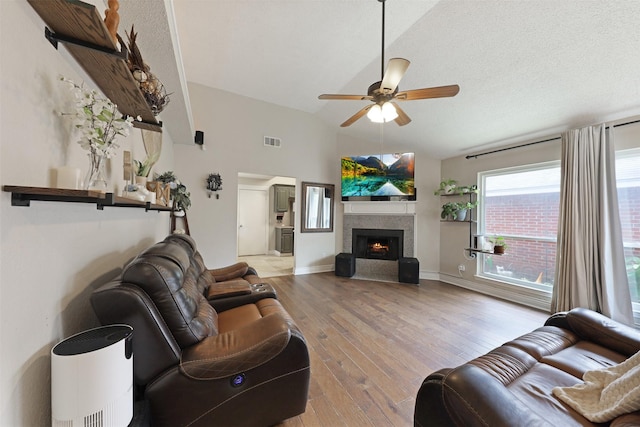 7340 Blackthorn Dr, Fort Worth, TX 76137 - living room with a ceiling fan, wood finished floors, lofted ceiling, a lit fireplace, and baseboards