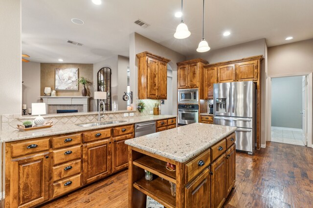kitchen featuring a sink, brown cabinetry, stainless steel appliances, and visible vents