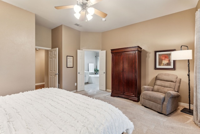 bedroom with light colored carpet, ensuite bathroom, visible vents, and baseboards