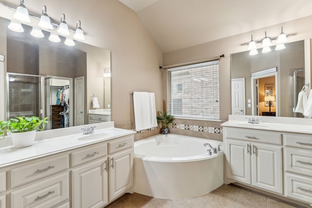 bathroom featuring a sink, vaulted ceiling, a stall shower, tile patterned flooring, and a garden tub