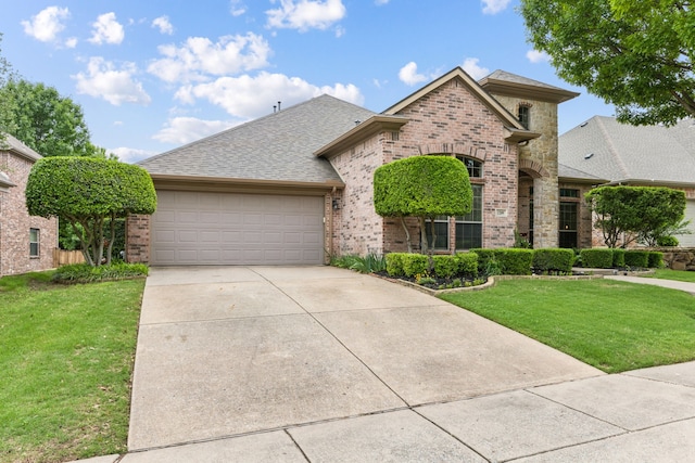 view of front of home with roof with shingles, brick siding, concrete driveway, a garage, and a front lawn
