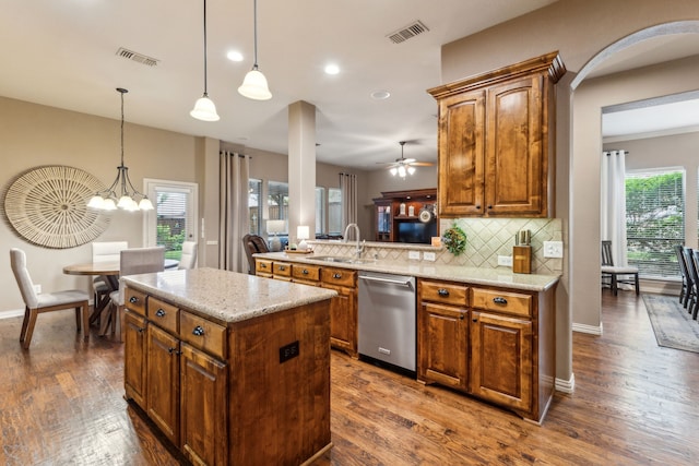 kitchen with a sink, backsplash, visible vents, and dishwasher
