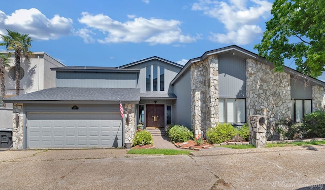 5705 Shoreline Dr, Shreveport, LA 71119 - mid-century modern home featuring an attached garage, a shingled roof, stone siding, and driveway