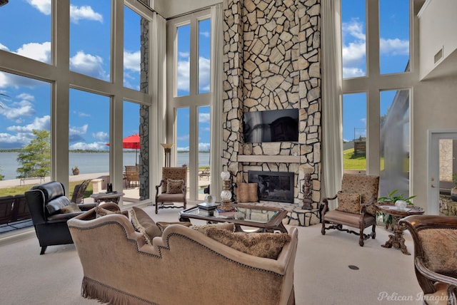 5705 Shoreline Dr, Shreveport, LA 71119 - living room featuring a water view, a stone fireplace, carpet, and a towering ceiling
