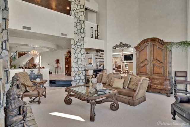 5705 Shoreline Dr, Shreveport, LA 71119 - carpeted living room with an inviting chandelier, visible vents, a towering ceiling, and ornate columns