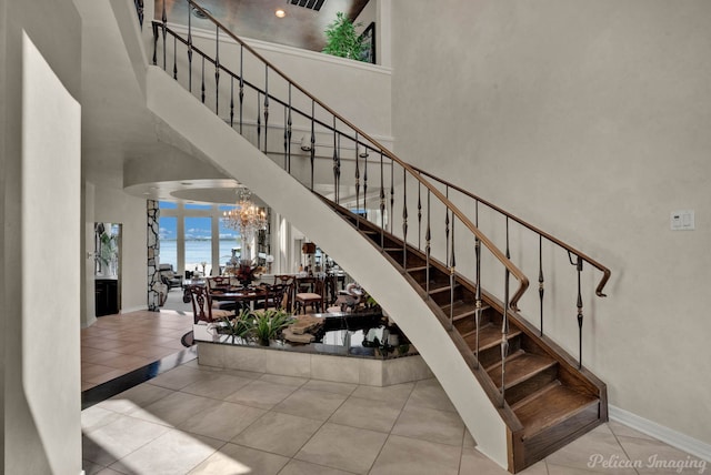 5705 Shoreline Dr, Shreveport, LA 71119 - stairs featuring a chandelier, a high ceiling, baseboards, and tile patterned floors