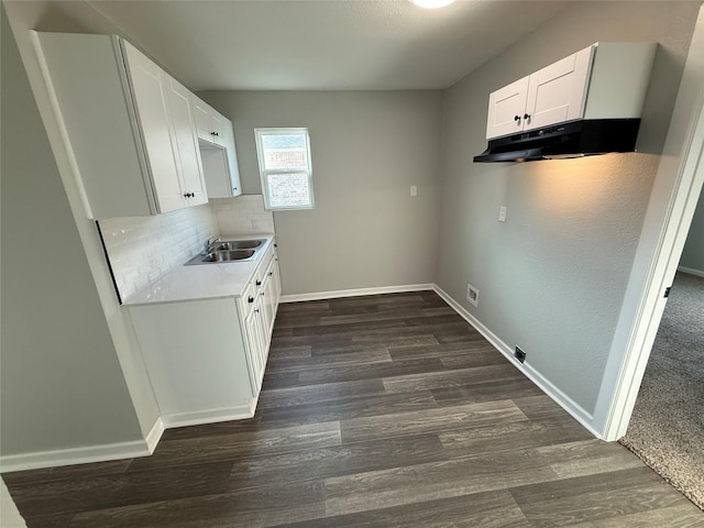 kitchen with under cabinet range hood, dark wood-style flooring, and baseboards