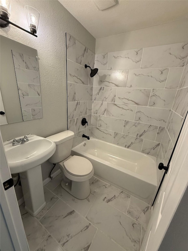 full bath with toilet, shower / washtub combination, marble finish floor, visible vents, and a textured wall