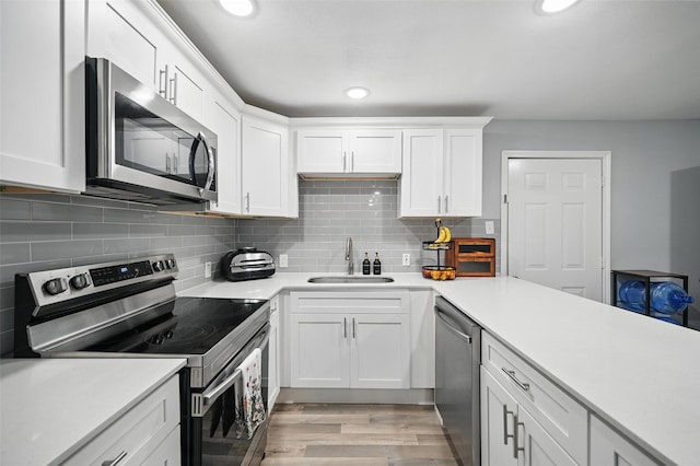 11519 Desdemona Dr, Dallas, TX 75228 - kitchen with stainless steel appliances, a sink, white cabinetry, light countertops, and recessed lighting