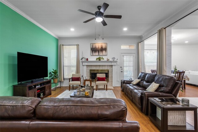 3811 Maywood Dr, Carrollton, TX 75007 - living room featuring a fireplace, crown molding, a ceiling fan, light wood-type flooring, and recessed lighting