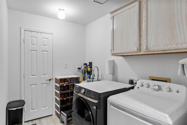 3811 Maywood Dr, Carrollton, TX 75007 - laundry room with cabinet space, washer and clothes dryer, and light wood-style flooring