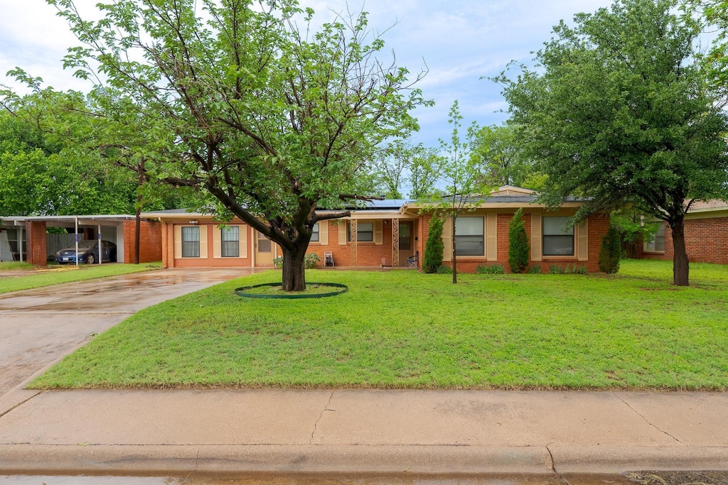 3954 State St, Abilene, TX 79603 - single story home featuring concrete driveway, brick siding, solar panels, and a front yard
