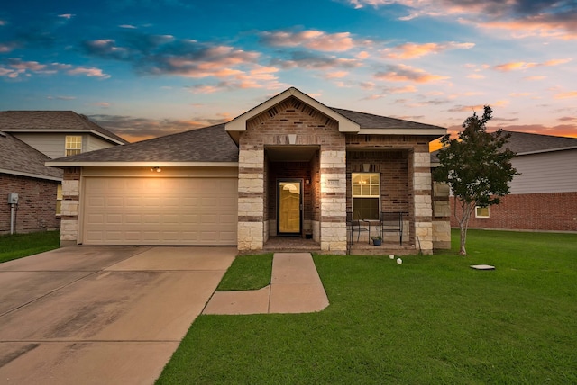 view of front of house with a garage, concrete driveway, a shingled roof, a front yard, and brick siding