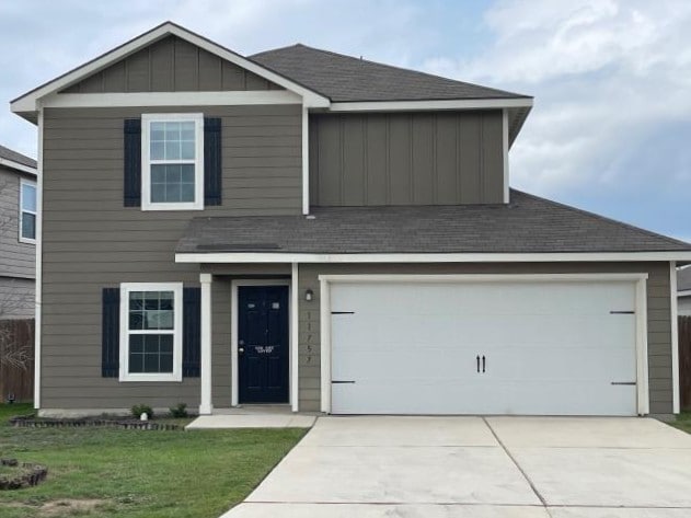 11757 Davalos Ln, San Antonio, TX 78252 - traditional home with driveway, board and batten siding, an attached garage, roof with shingles, and a front lawn