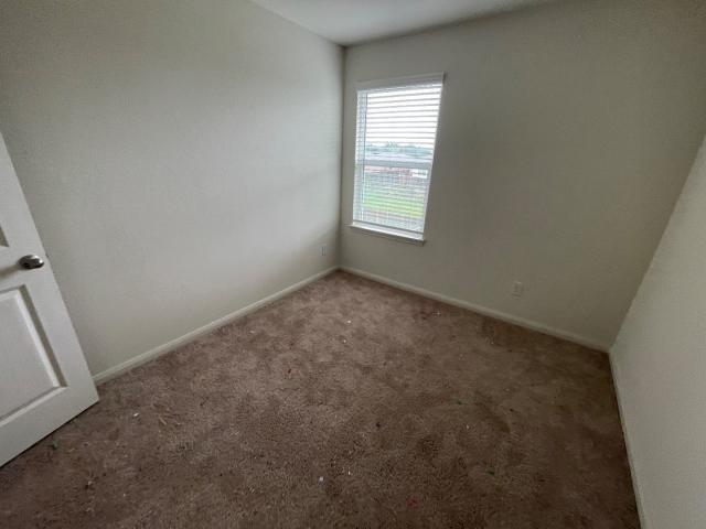 11757 Davalos Ln, San Antonio, TX 78252 - spare room featuring baseboards and carpet
