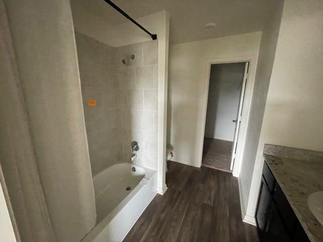 11757 Davalos Ln, San Antonio, TX 78252 - bathroom with shower / bath combo with shower curtain, baseboards, wood finished floors, and vanity