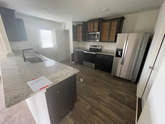 11757 Davalos Ln, San Antonio, TX 78252 - kitchen with a sink, a peninsula, stainless steel appliances, dark wood finished floors, and glass insert cabinets