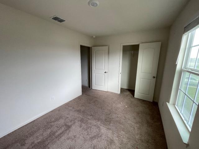 11757 Davalos Ln, San Antonio, TX 78252 - unfurnished bedroom featuring carpet flooring, a closet, and visible vents