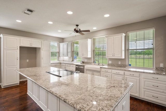 kitchen featuring a center island, white cabinets, ceiling fan, electric stovetop, and dishwasher
