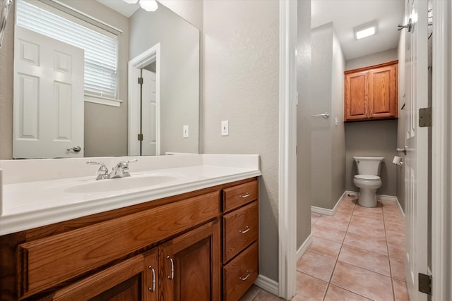 bathroom featuring toilet, baseboards, tile patterned flooring, and vanity
